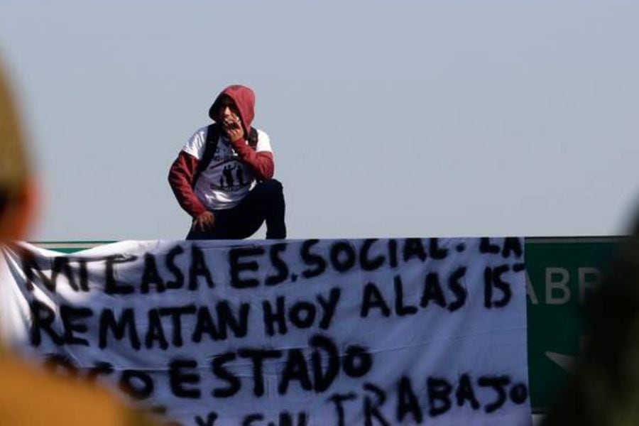 Hombre trepa un letrero vial para protestar contra el inminente remate de su casa