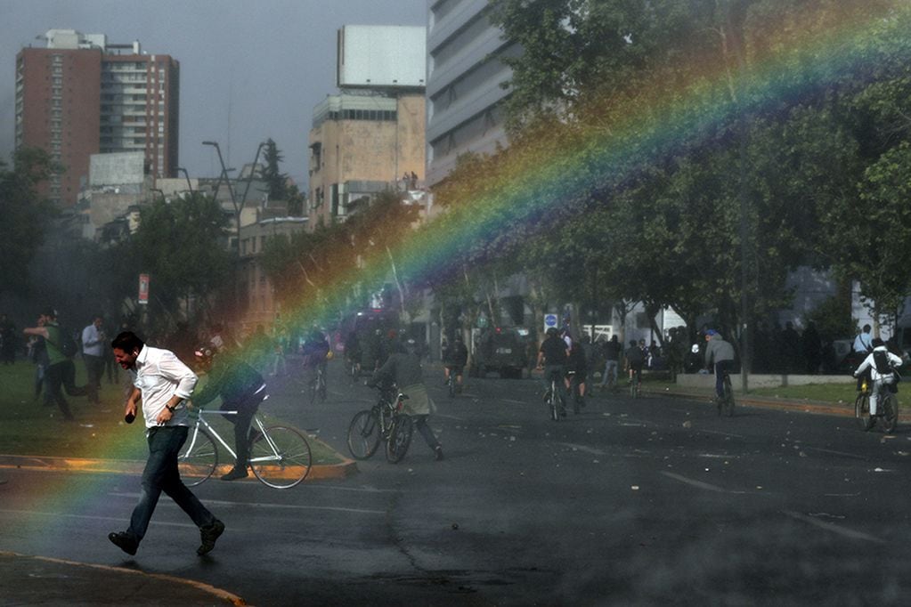 A demonstrator runs away from the police water cannon during a protest against the increase in subway ticket prices in Santiago, Chile, October 19, 2019. REUTERS/Ivan Alvarado