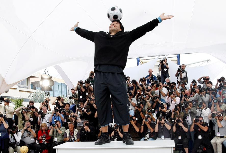 FILE PHOTO: Former soccer star Maradona balances a ball on his head during a photocall at the 61st Cannes Film Festival