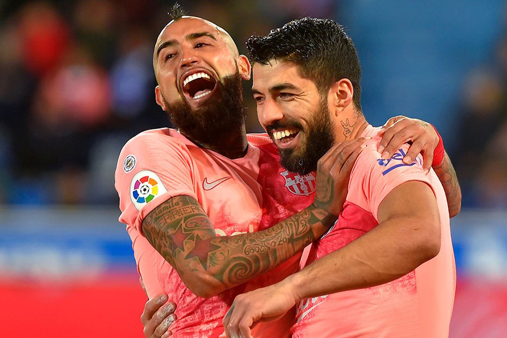 Barcelona's Uruguayan forward Luis Suarez (R) celebrates with Barcelona's Chilean midfielder Arturo Vidal after scoring a penalty during the Spanish league football match between Deportivo Alaves and FC Barcelona at the Mendizorroza stadium in Vitoria on April 23, 2019. / AFP / ANDER GILLENEA

