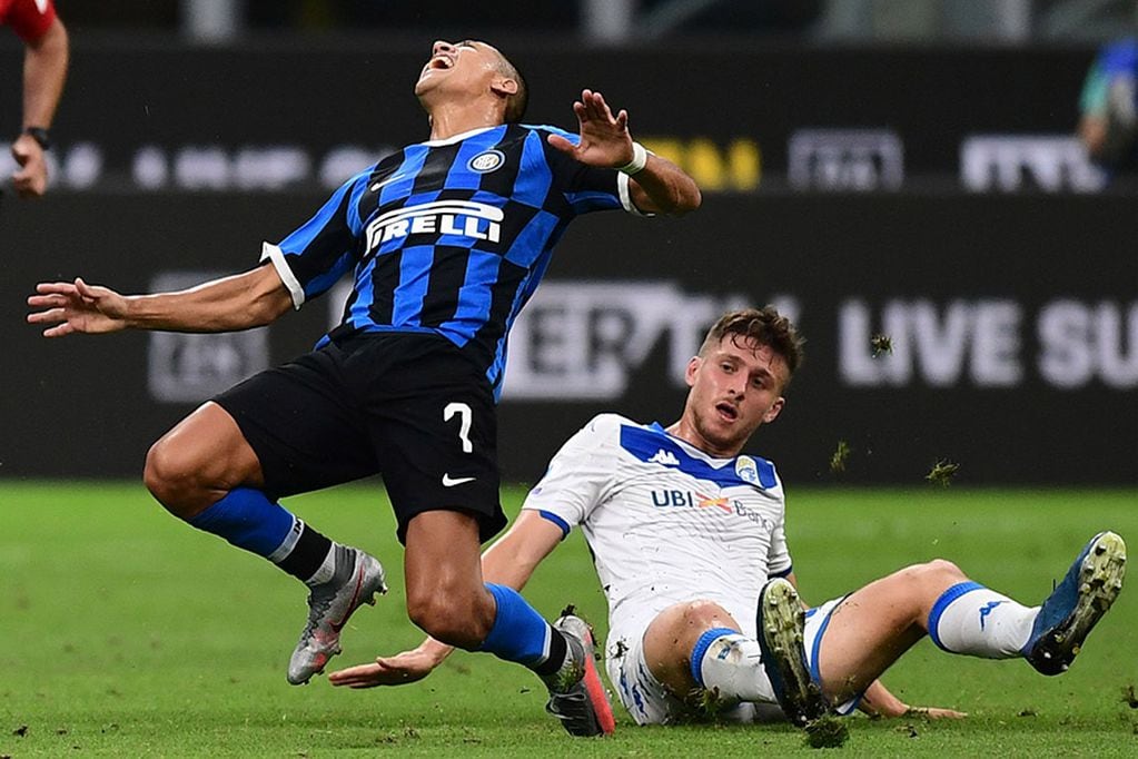 Brescia's Italian midfielder Alessandro Semprini (R) tackles Inter Milan's Chilean forward Alexis Sanchez during the Italian Serie A football match Inter vs Brescia played behind closed doors on July 1, 2020 at the Giuseppe-Meazza San Siro stadium in Milan, as the country eases its lockdown aimed at curbing the spread of the COVID-19 infection, caused by the novel coronavirus. (Photo by Miguel MEDINA / AFP)