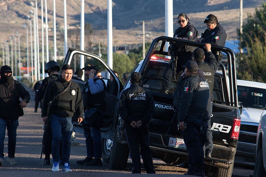 Police officers stand atop a vehicle as they keep watch outside the prison after sixteen inmates were killed and five were wounded in a prison fight at the Regional Center for Social Reintegration in the town of Cieneguillas