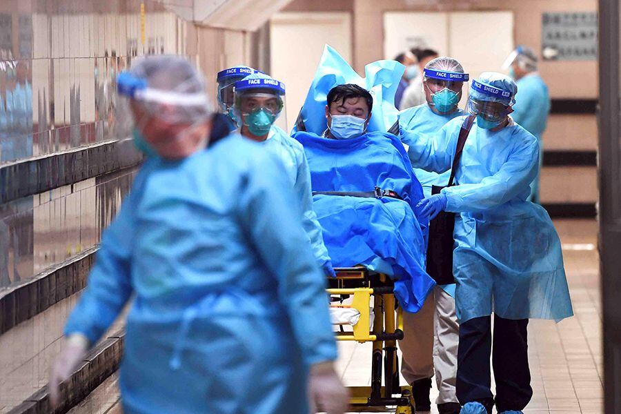 Medical staff transfer a patient of a highly suspected case of a new coronavirus at the Queen Elizabeth Hospital in Hong Kong